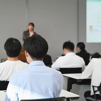 会議室で講師の講義を聴く学生たちの後ろ姿
